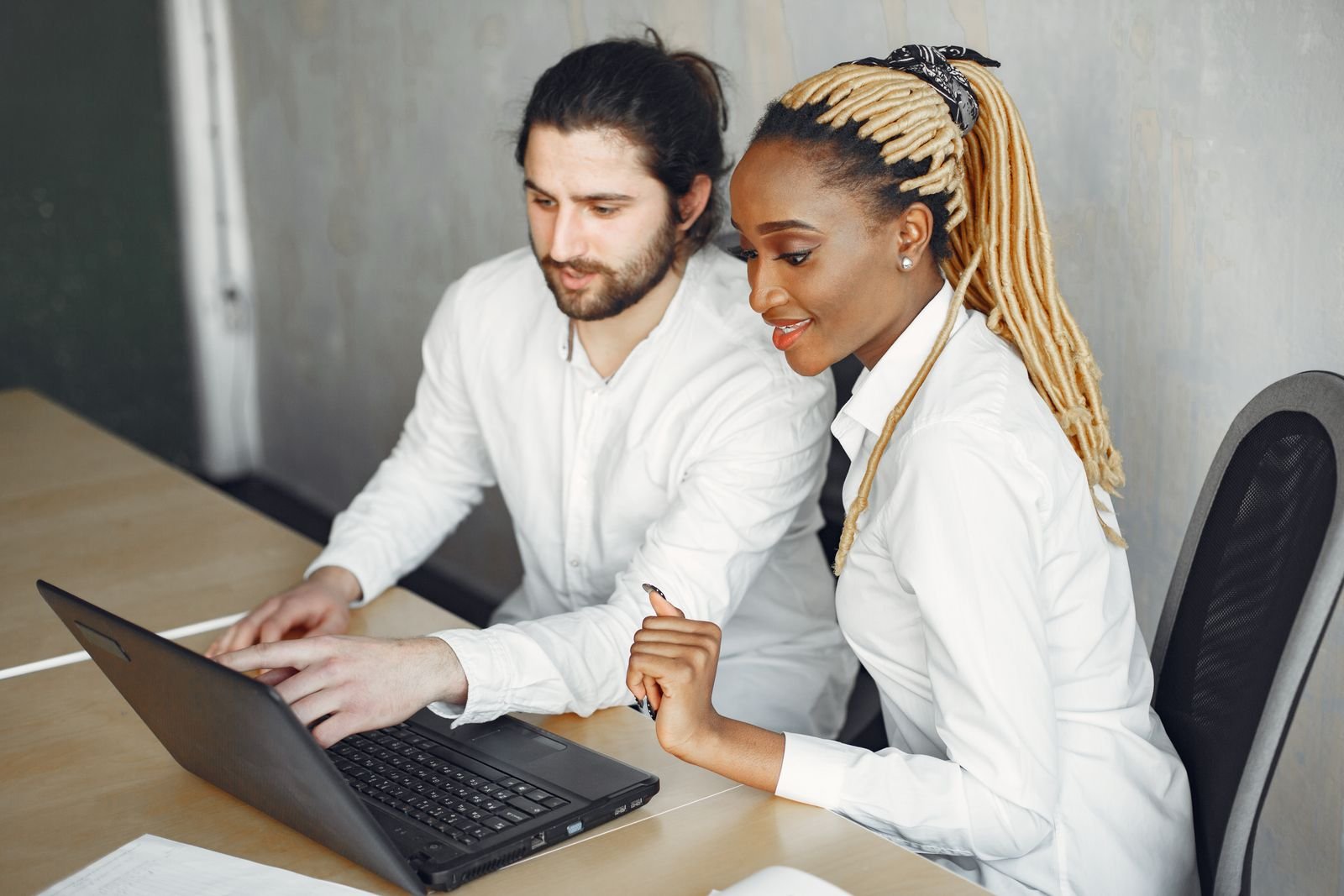 Two professionals collaborating at a laptop